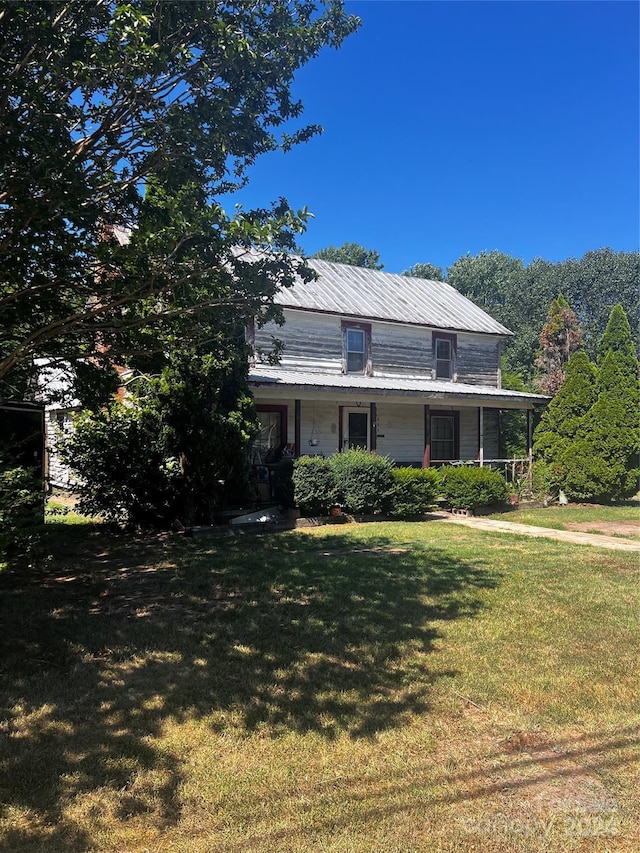 farmhouse featuring a front lawn and a porch