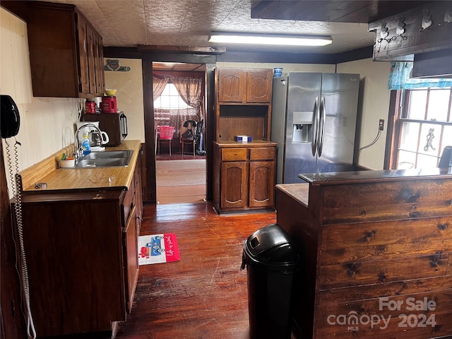 kitchen with stainless steel fridge with ice dispenser, dark wood-type flooring, and sink