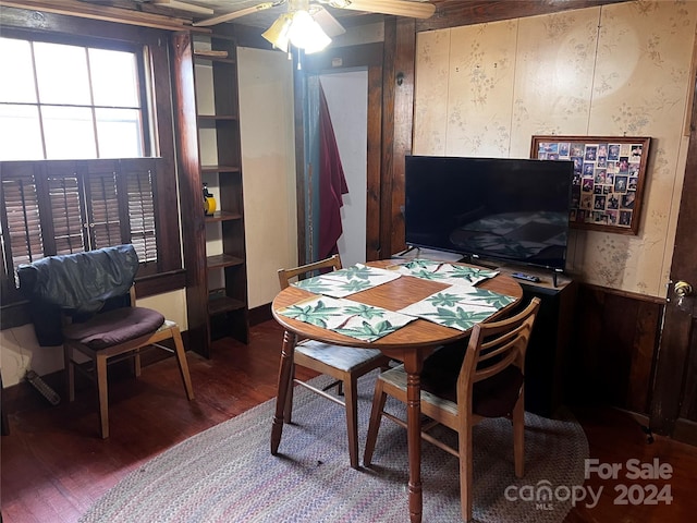 office area with ceiling fan, wood walls, and hardwood / wood-style floors