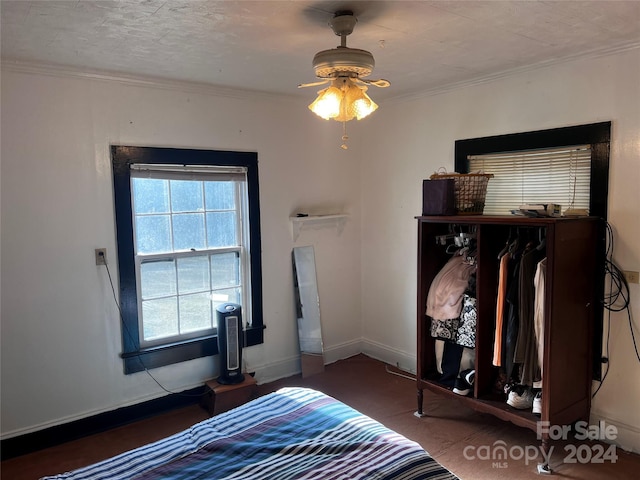 bedroom with ceiling fan, a textured ceiling, and ornamental molding