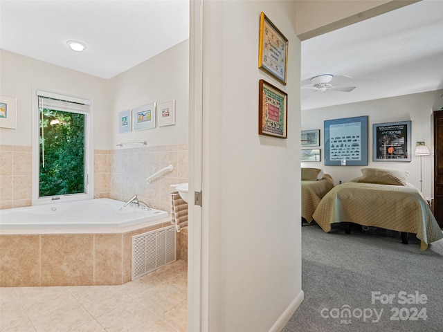 bathroom with tile patterned floors, ceiling fan, and tiled bath