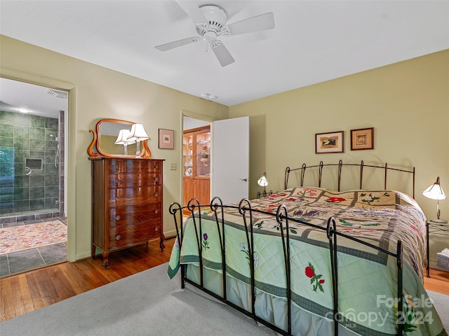 bedroom featuring connected bathroom, hardwood / wood-style flooring, and ceiling fan