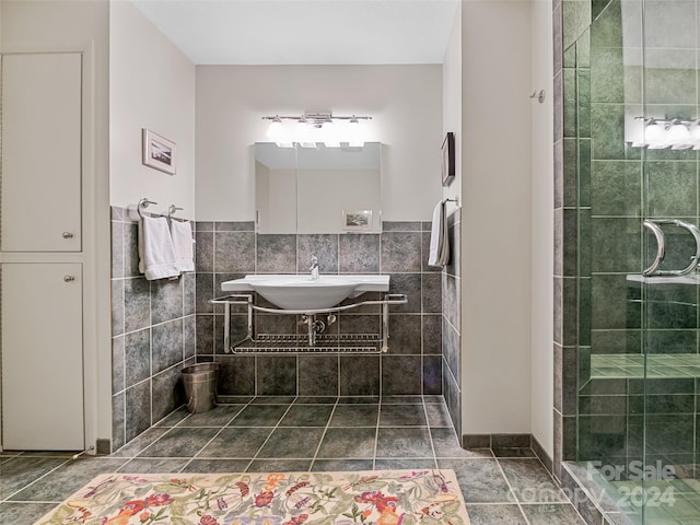 bathroom with vanity, tiled shower, tile patterned floors, and tile walls