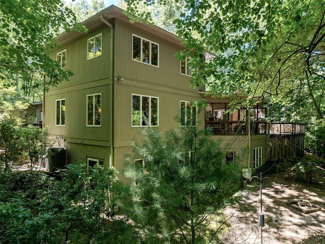 view of home's exterior featuring cooling unit and a wooden deck