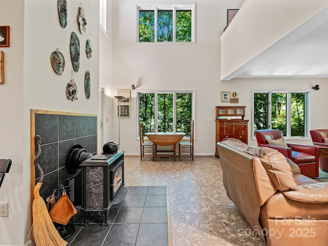 living room with a towering ceiling and a wood stove