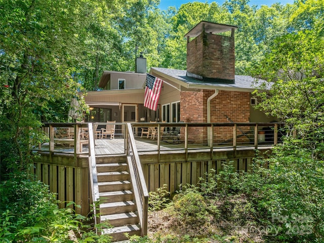 rear view of house with a sunroom and a deck