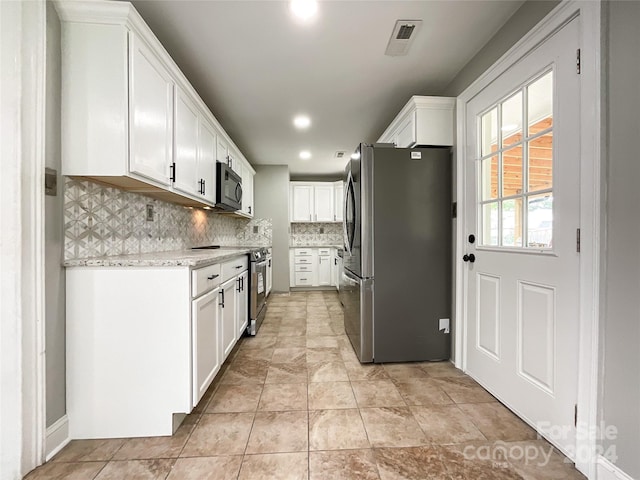 kitchen featuring tasteful backsplash, white cabinets, and stainless steel appliances