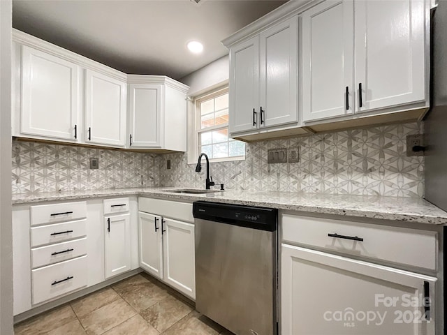 kitchen with dishwasher, light stone counters, white cabinetry, and sink