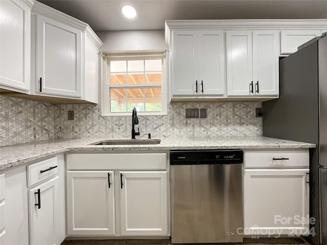 kitchen with light stone countertops, sink, white cabinetry, and stainless steel appliances