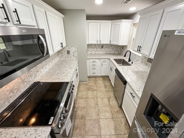 kitchen with tasteful backsplash, white cabinetry, sink, and stainless steel appliances