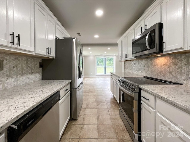 kitchen featuring white cabinets, backsplash, stainless steel appliances, and light stone counters