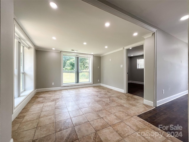 tiled spare room with crown molding and a wealth of natural light