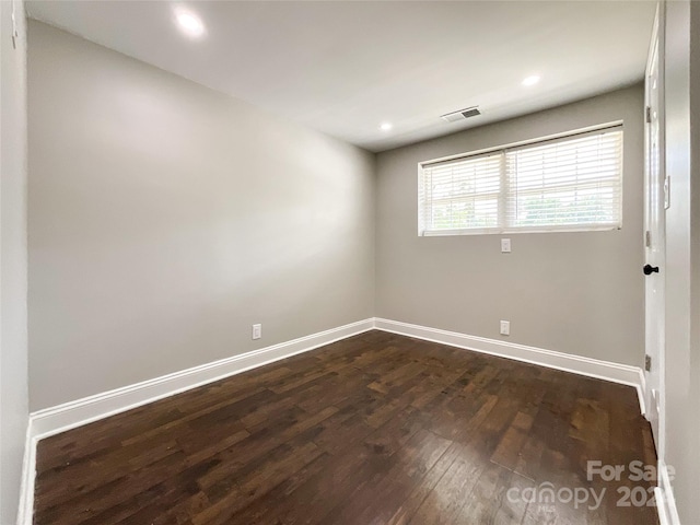 unfurnished room with dark wood-type flooring