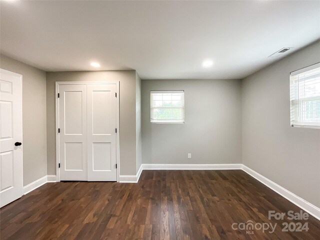 unfurnished bedroom with a closet and dark wood-type flooring