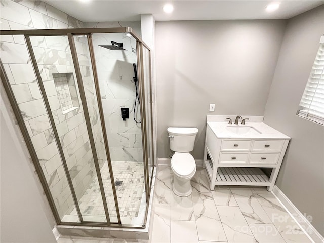 bathroom featuring a shower with door, vanity, and toilet