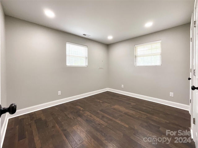 empty room with dark hardwood / wood-style flooring