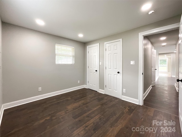 unfurnished bedroom with dark wood-type flooring