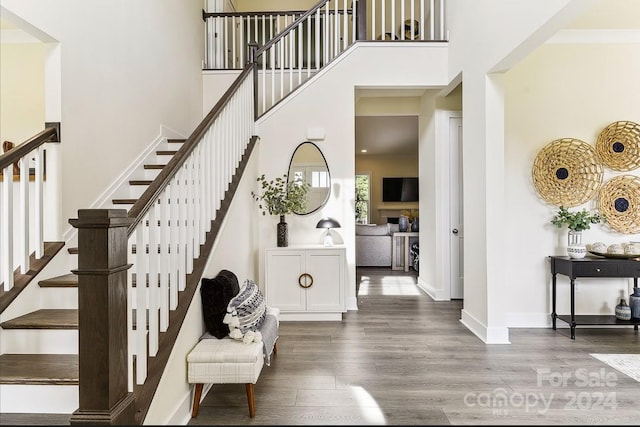 staircase featuring a high ceiling and hardwood / wood-style flooring