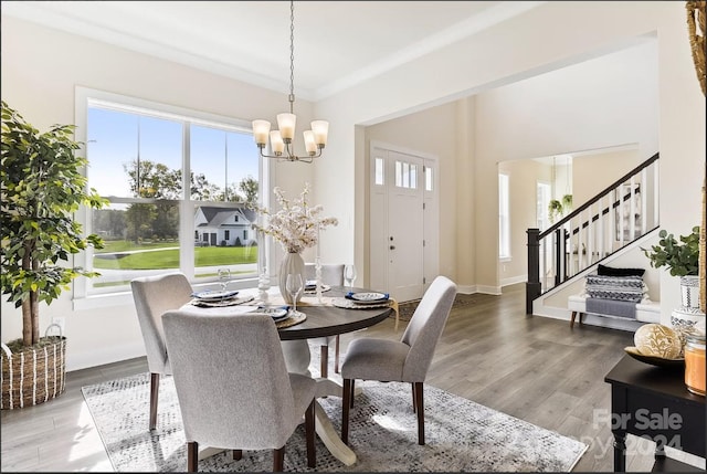 dining space featuring a healthy amount of sunlight, hardwood / wood-style floors, and a notable chandelier