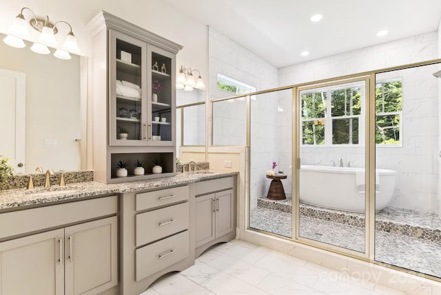 bathroom featuring separate shower and tub, vanity, and tile walls