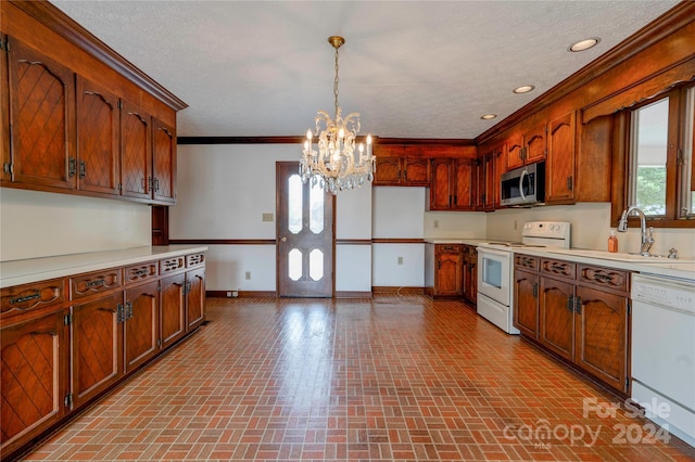 kitchen with hanging light fixtures, an inviting chandelier, crown molding, a textured ceiling, and white appliances