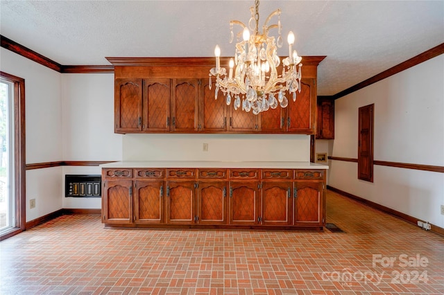 kitchen with a wealth of natural light, a textured ceiling, an inviting chandelier, and hanging light fixtures