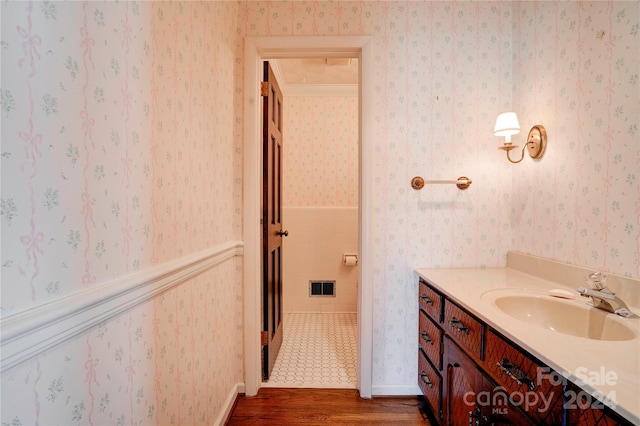 bathroom with hardwood / wood-style floors, vanity, and crown molding