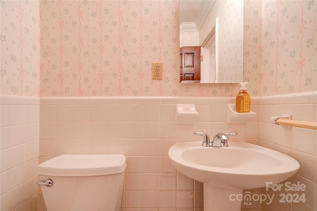 bathroom featuring toilet, tile walls, and crown molding