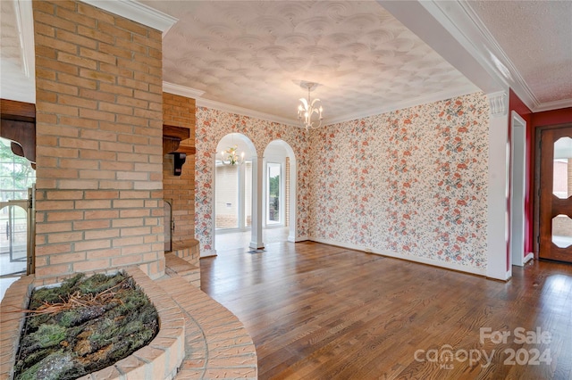 foyer featuring hardwood / wood-style floors, ornamental molding, and a textured ceiling