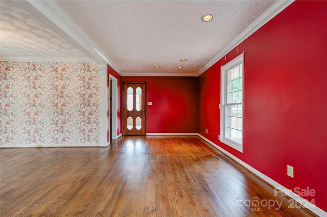 foyer entrance featuring crown molding, a textured ceiling, and hardwood / wood-style flooring