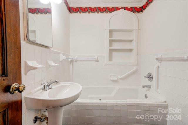 bathroom with tiled bath and built in features