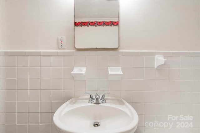 bathroom with sink and tile walls