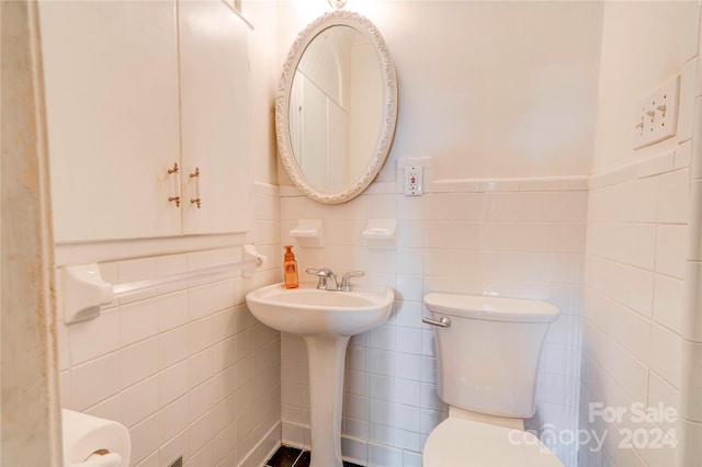 bathroom with tile walls and toilet