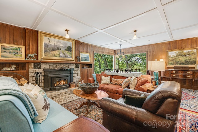 living room featuring wooden walls, coffered ceiling, and a fireplace