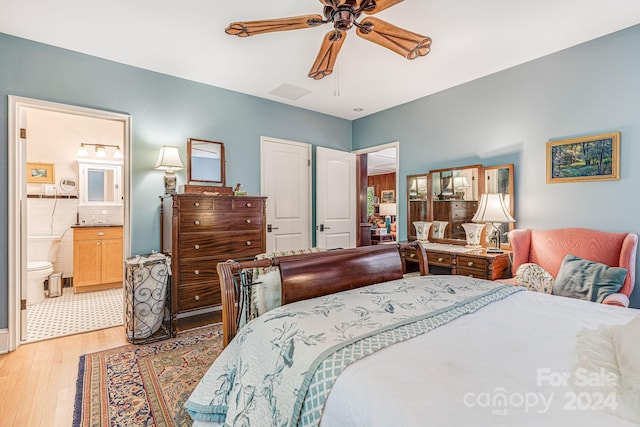 bedroom with connected bathroom, light hardwood / wood-style flooring, and ceiling fan