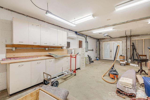 basement featuring electric panel and a wall mounted AC