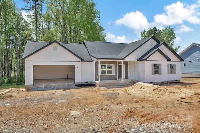 view of front of property with an attached garage, crawl space, covered porch, and a shingled roof