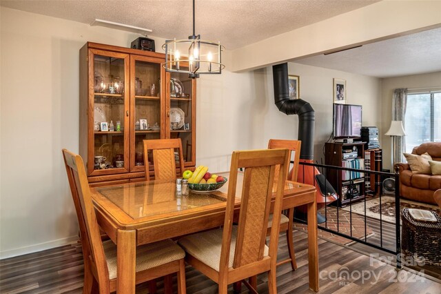 dining room featuring dark hardwood / wood-style flooring, an inviting chandelier, and a textured ceiling