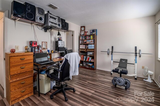 home office with a healthy amount of sunlight, dark hardwood / wood-style flooring, and a textured ceiling