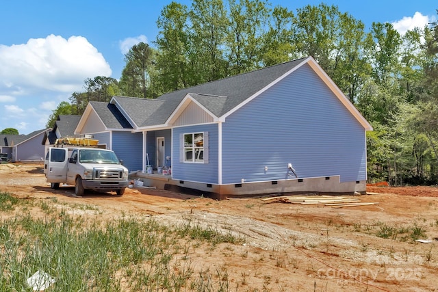 exterior space featuring crawl space and a shingled roof