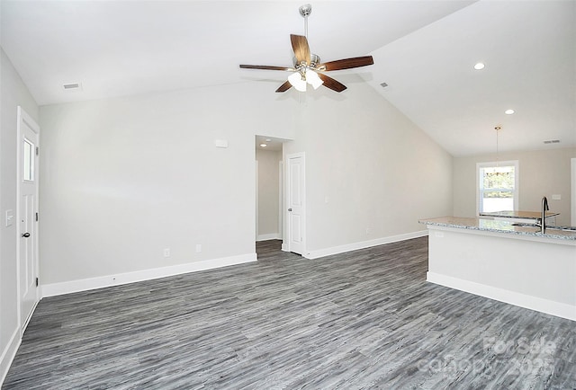 unfurnished living room with dark wood-type flooring, baseboards, ceiling fan, and a sink