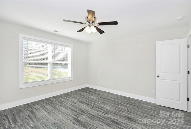 empty room with dark wood finished floors, visible vents, baseboards, and ceiling fan