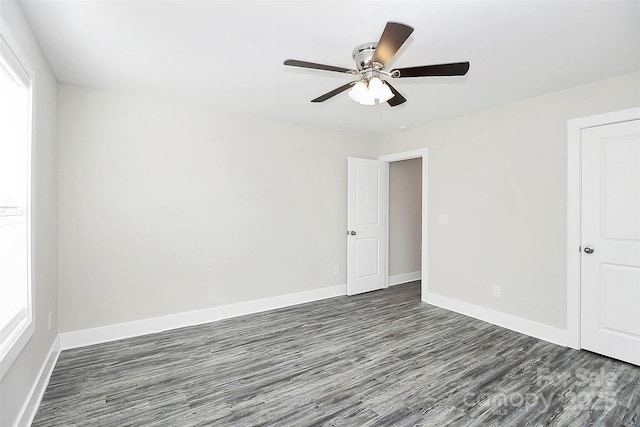 unfurnished bedroom featuring baseboards, ceiling fan, and dark wood-style flooring