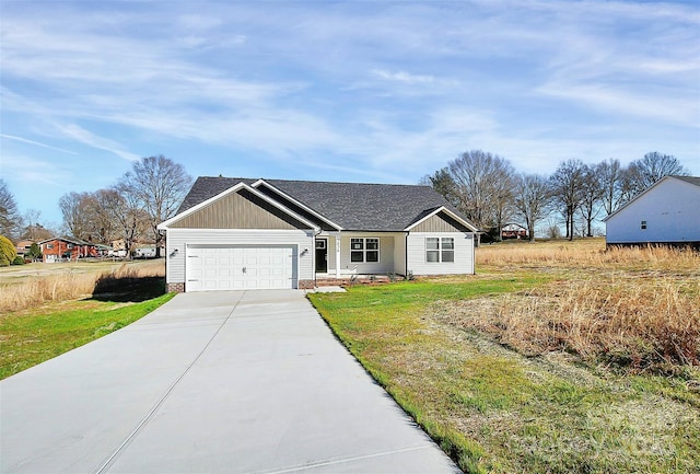 view of front of home with concrete driveway, an attached garage, roof with shingles, and a front yard