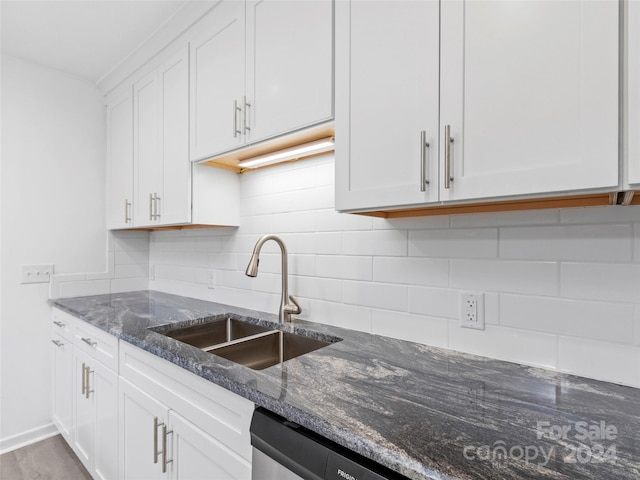 kitchen with white cabinets, dark stone counters, and sink