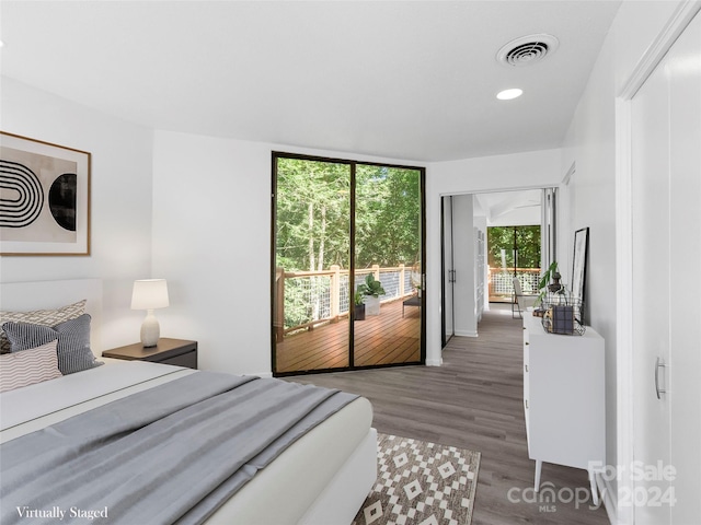 bedroom featuring dark hardwood / wood-style floors, access to outside, and multiple windows