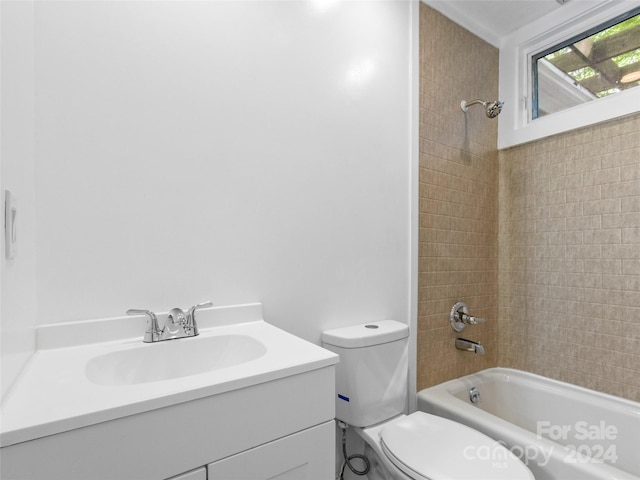 full bathroom with toilet, tiled shower / bath combo, and vanity