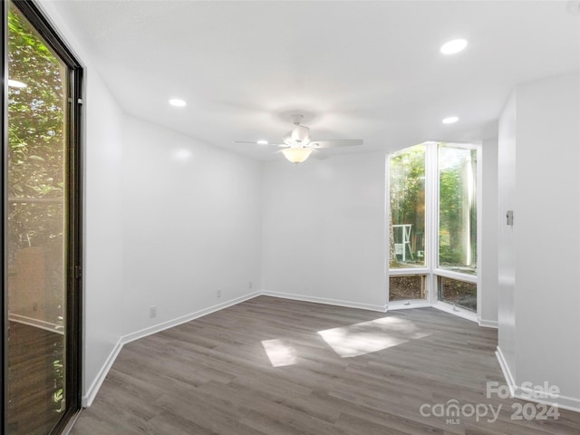 spare room with ceiling fan, dark hardwood / wood-style floors, and floor to ceiling windows