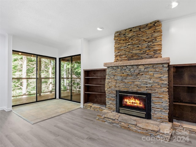 unfurnished living room featuring a textured ceiling, light hardwood / wood-style floors, and a fireplace