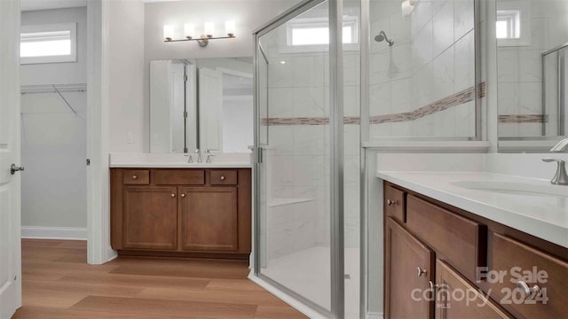 bathroom featuring hardwood / wood-style flooring, vanity, and a shower with shower door